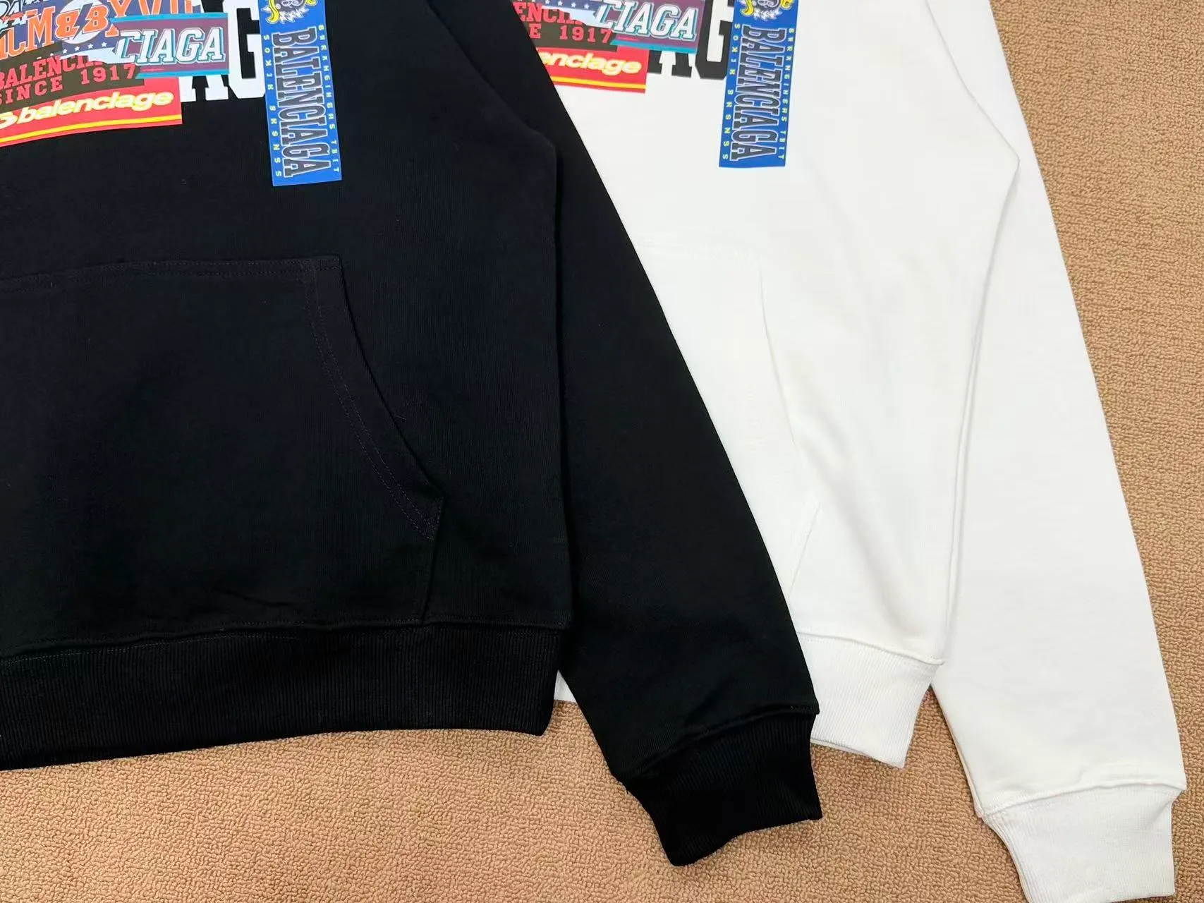 Style No. 2202 • Color: Black / White available • Version: Loose shoulder oversize version, regardless of figure, same style for men and women • Style: Pullover hooded sweatshirt, front kangaroo pocket, casual Versatile 🧶Fabric technology: Made of 420 high-gram weight cotton terry fabric, soft and thick to the touch, comfortable and Breathable on the upper body; threaded cuffs + hem, not easy to deform after long-term wear. The printing adopts high-definition offset printing, multi-layer label sticker style pattern, the color is full and firm, and the large pattern on the back has strong visual impact. 🎨Design highlights: Retro collage label printing, multi-layer BALENCIAGA letter logo superimposed, full of street fashion sense. Simple hooded basic version + exaggerated back print, low-key and recognizable, with a high-end and lazy atmosphere. 🧥Wearing scenarios: Suitable for daily commuting, shopping and outings, and campus wear. The lower body can be worn with jeans, sports pants, or shark pants. The loose fit hides the flesh and makes you look slimmer. It is perfect for couples. Sizes m l xl